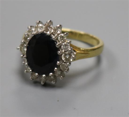A modern 18ct gold, sapphire and diamond oval cluster ring, size N.